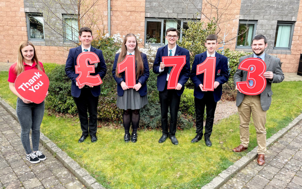 WCB students alongside NICHS representative with numbers representing the £1713 donation