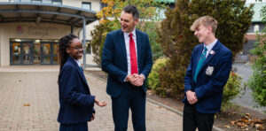 School entrance banner with students and principal